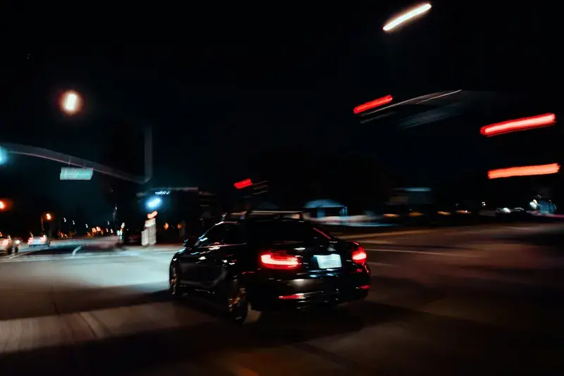 A car driving down a street at night